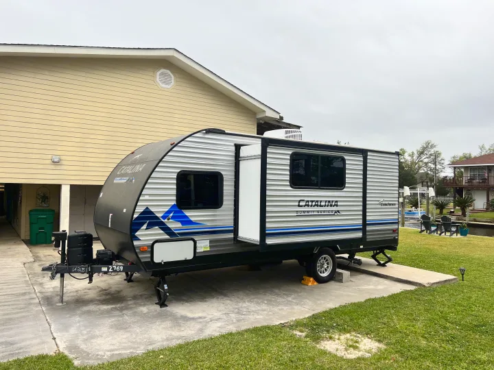 This **RV rental** travel trailer is parked with its slide extended at a canal-front property.. Forest River Coachmen Catalina Summit 2022