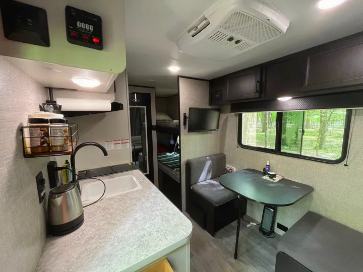 Spacious RV rental interior featuring a modern kitchen, cozy dining area, and bunk beds. Perfect for family adventures.. Jayco Jay Flight 2022