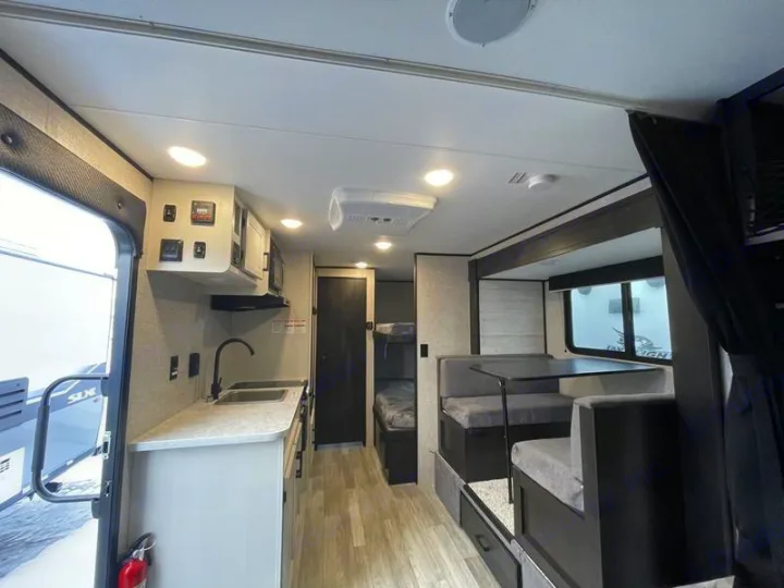 Explore this bright RV rental interior with a fully equipped kitchen, comfortable dinette, and bunk beds. Ideal for your next trip.. Jayco Jay Flight SLX 2022