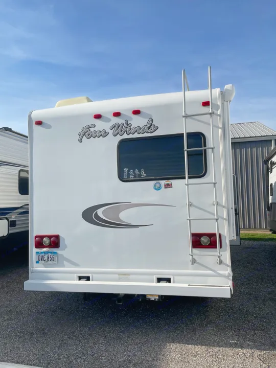The back of a white Four Winds RV rental with a ladder, window decals, and Iowa license plate.. Thor Four Winds 2015