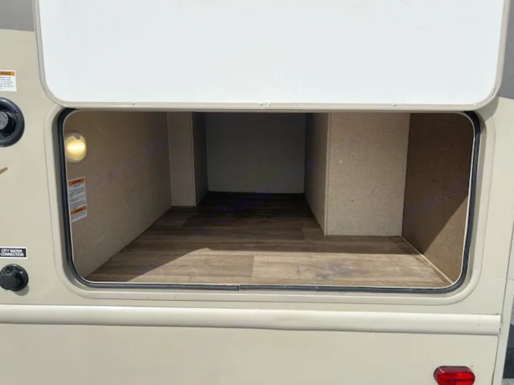 RV rental: Illuminated exterior storage compartment with wood-patterned floor. Great for your travel gear.. Thor Motor Coach Freedom Elite 2017