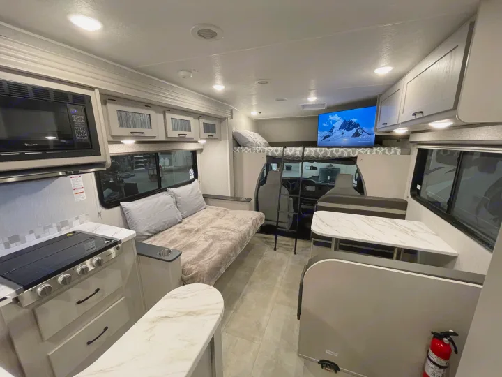 This rv rental offers a well-appointed interior with a kitchen, dinette, and bunk/bed areas, designed for comfort on the road.. Coachmen Freelander 2024