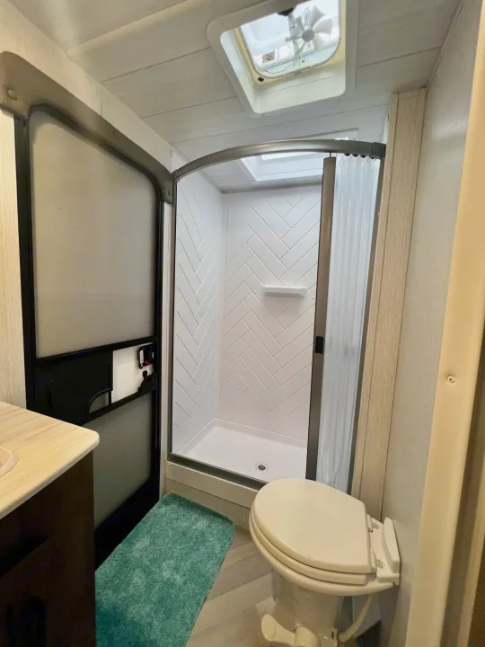 RV rental bathroom with modern shower, toilet, and vanity. Compact and functional for comfortable travel.. Forest River Wildwood X-Lite 2022