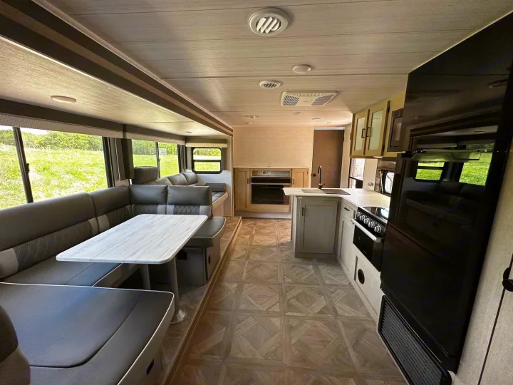 RV rental: Bright interior featuring a modern kitchen, large U-shaped dinette, & scenic outdoor views.. Forest River Wildwood X-Lite 2023