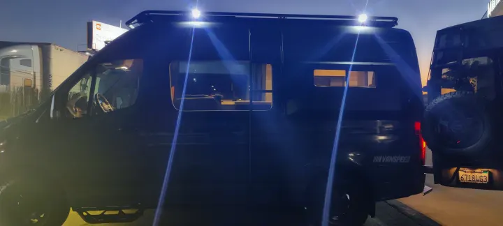 VANSPEED custom camper van, available as an RV rental. Dark van with bright roof lights and cozy interior at dusk.. Mercedes Sprinter 2021