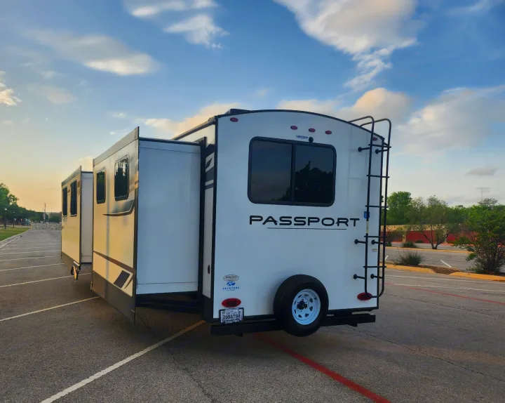 White Keystone Passport travel trailer with slides extended, parked. Perfect for your next rv rental.. Keystone RV Passport GT Ultra Lite 2023