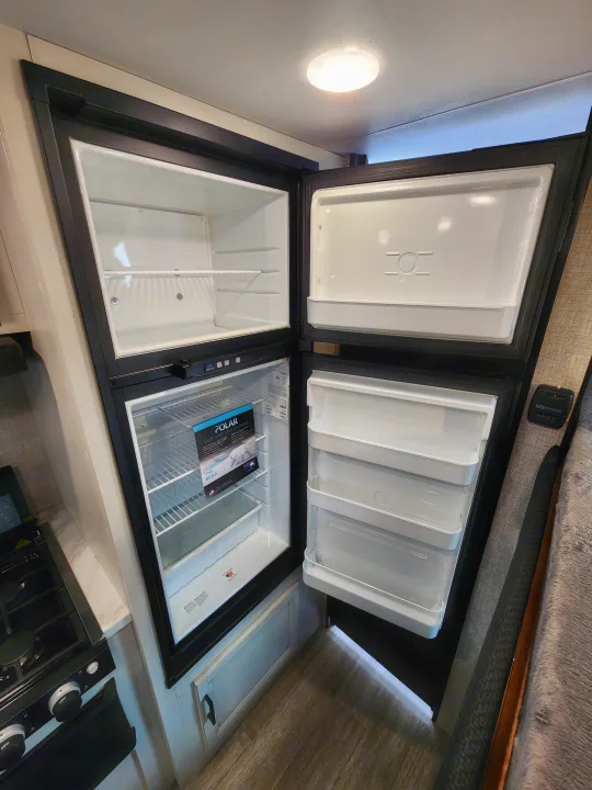 Interior view of open top-loading RV refrigerator/freezer units, perfect for your RV rental adventure.. Jayco slx 2023