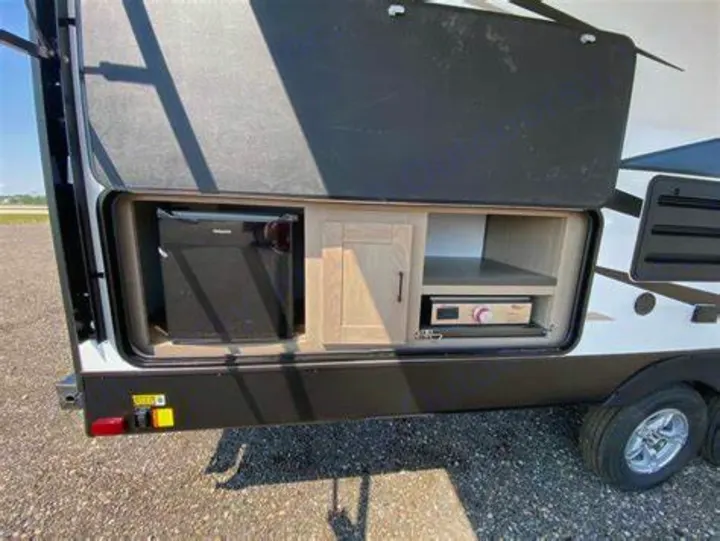 This RV rental features a convenient outdoor kitchen with a mini-fridge, cabinet, and pull-out griddle for easy cooking.. Heartland RVs Sundance Ultra Lite 2022