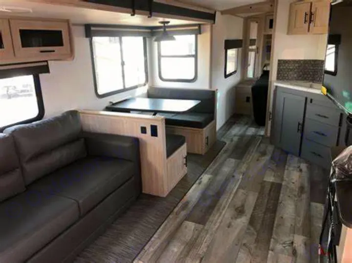 Spacious RV rental interior with modern kitchen, comfortable sofa, and dining booth.. Heartland RVs Sundance Ultra Lite 2022