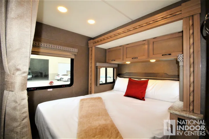 Step into comfort with this modern RV rental bedroom featuring a spacious bed, ample storage, and stylish decor.. Thor Motor Coach Freedom Elite 2018
