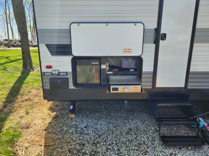 Enjoy an rv rental with a fully equipped outdoor kitchen: griddle, fridge, and easy access steps for a great campsite experience.. Sportsmen Other 2022