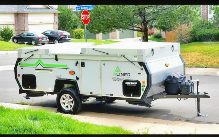 Explore with this A-Liner pop-up RV rental, a compact travel trailer parked on a sunny residential street.. A-liner Classic 2022