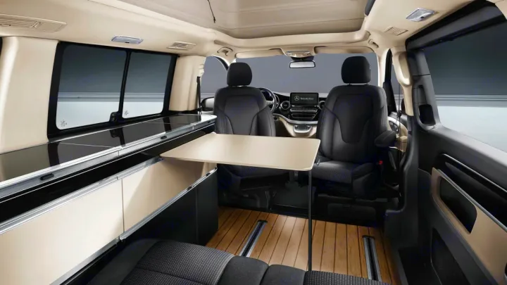 Modern Mercedes-Benz camper van interior. An ideal RV rental, it boasts a compact kitchen, versatile table, and comfortable seating.. Mercedes Class V Marco Polo 2023