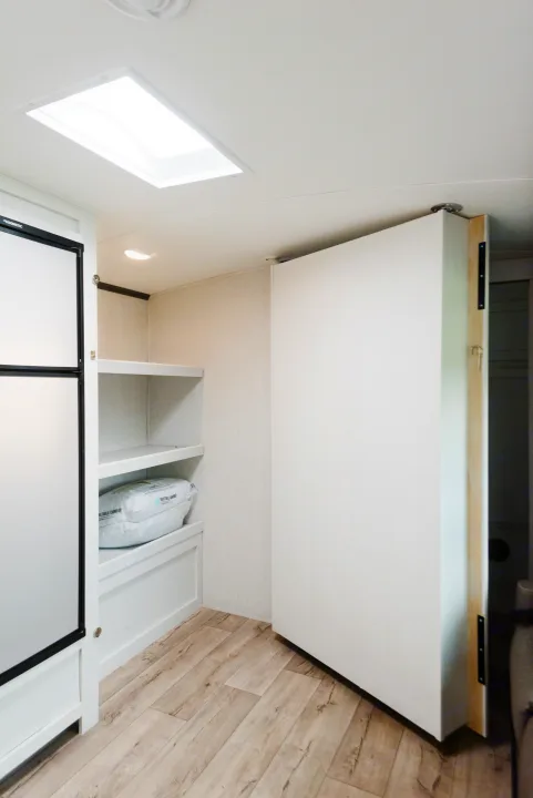 RV rental: Bright, modern interior featuring a Dometic fridge, storage shelves, and a versatile folding partition.. Dutchmen Astoria 2022