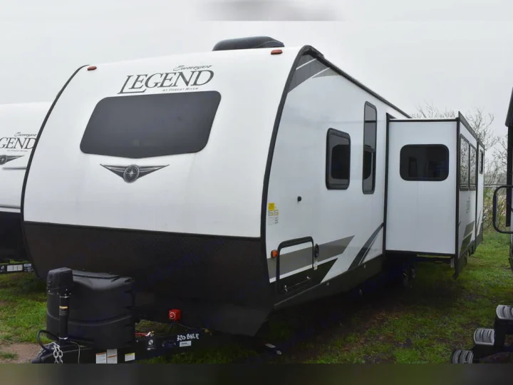 White Forest River Legend travel trailer with extended slide-out, great for rv rental adventures.. Forest River Surveyor 2021