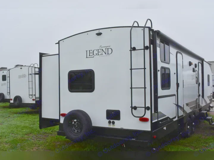White "Surveyor LEGEND" RVs with rear ladders & slide-outs on a grassy lot. Perfect for your next RV rental.. Forest River Surveyor 2021