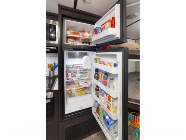 Well-stocked RV rental refrigerator/freezer provides ample food storage, perfect for your travels and mobile living.. Forest River Surveyor 2021