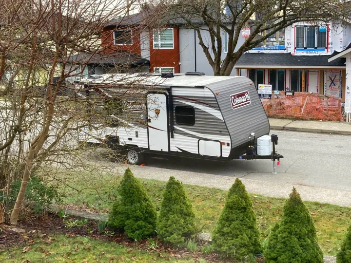A Coleman travel trailer (RV) parked on a residential street, hinting at an RV rental experience.. Dutchmen Coleman Lantern LT 2019