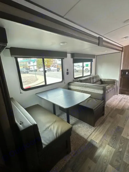 RV rental interior: Spacious dinette with table and benches inside a modern travel trailer.. Keystone RV Springdale 2021