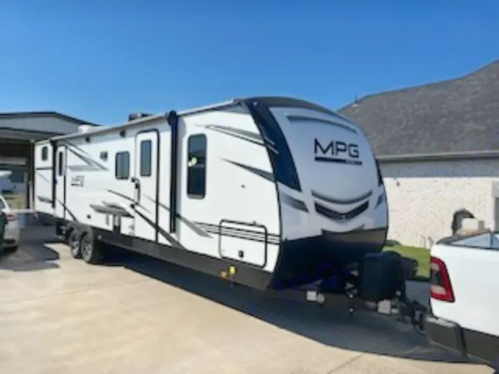 A sleek white MPG travel trailer, hitched to a pickup truck, awaits your next RV rental journey. Ideal for family road trips.. Cruiser Rv Corp Cruiser 2021