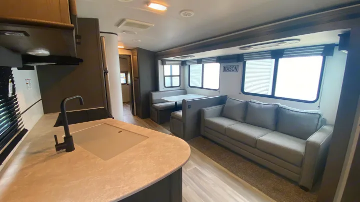 Modern RV rental interior featuring a bright kitchen, a dining booth, and a comfortable living area with a sofa.. Cruiser Rv Corp Cruiser 2021
