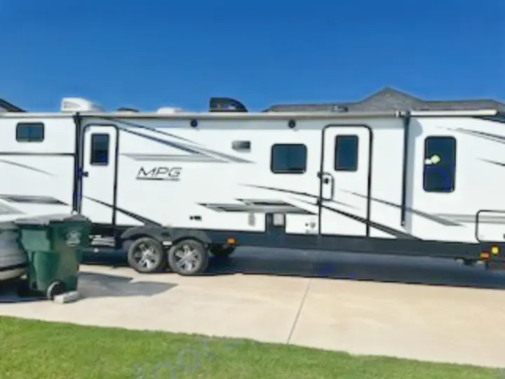 Bright white MPG travel trailer, with multiple windows and doors, parked on a driveway. Ready for an RV rental adventure.. Cruiser Rv Corp Cruiser 2021