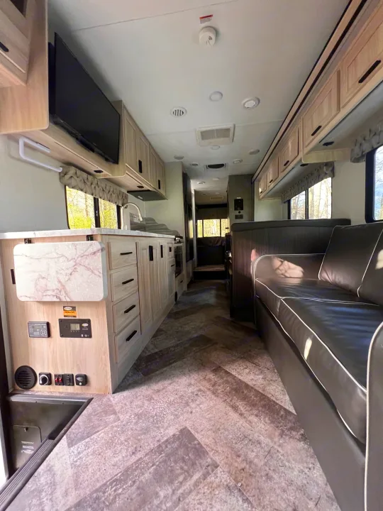 Step inside this spacious rv rental, featuring a modern kitchen, comfy sofa, and ample storage for your journey.. Forest River Sunseeker Classic 2020