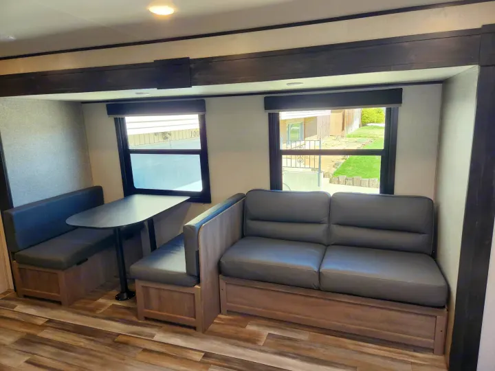 Cozy RV rental interior showcasing a spacious dinette area and a comfortable sofa, ideal for travel and relaxation.. Starcraft Autumn Ridge 2022