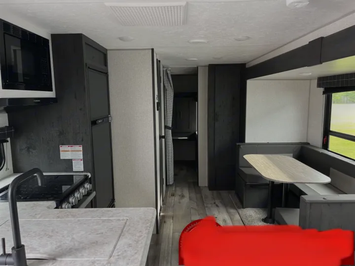 Inside this RV rental: Modern kitchen, long hallway, and cozy dinette booth with table. Ready for travel!. K-Z Manufacturing Sportsman Classic 2022
