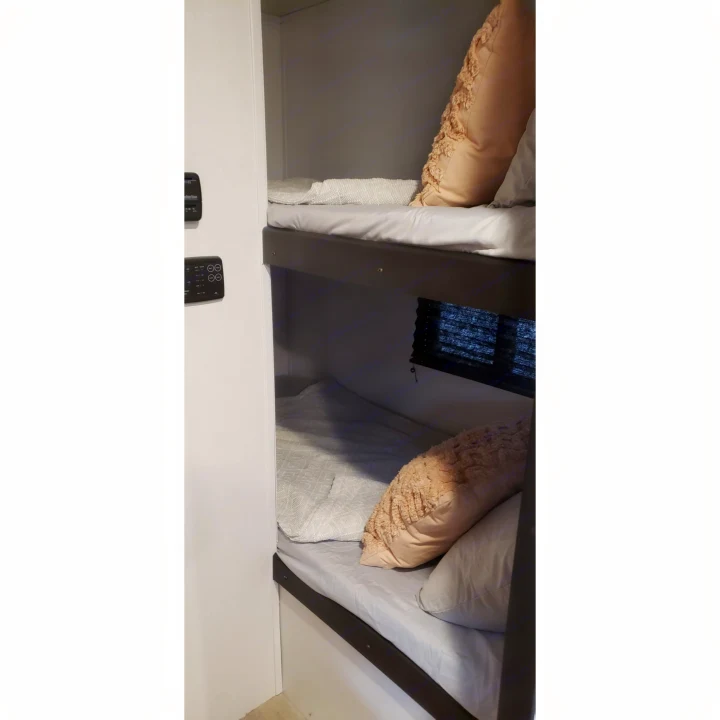 View inside an RV rental, showing two comfortable, stacked bunk beds with pillows.. Keystone RV Springdale 2022
