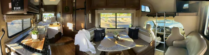 Panoramic view of a modern RV rental. Highlights: well-appointed kitchen, comfortable bed, cozy dinette, and front cab.. Thor Four Winds 2020