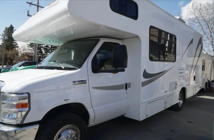 This clean, white Class C RV, possibly an rv rental, is ready for your next adventure as a comfortable recreation vehicle.. Thor Majestic 2012