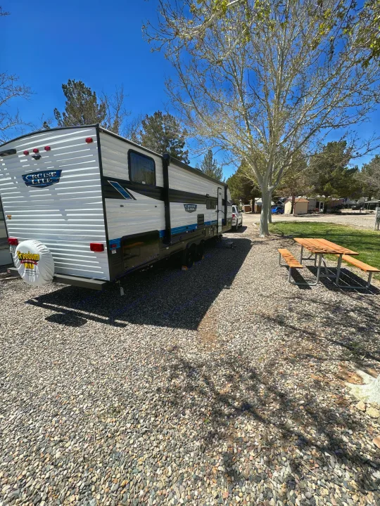 Cruise Lite RV rental travel trailer at a sunny gravel campsite with a picnic table, perfect for your next adventure.. Forest River Salem Cruise Lite T282QXBL 2023