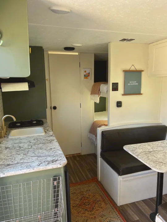 Inside a stylish RV rental: a modern kitchen, dining area, and comfy bunk beds. Ideal for your next trip!. Keystone RV Hideout 2018