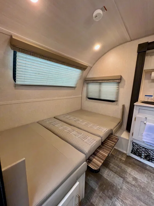 Inside a cozy **rv rental**: convertible beds, bright windows with blinds, and a compact kitchen counter.. Forest River R-Pod RP-190 2021