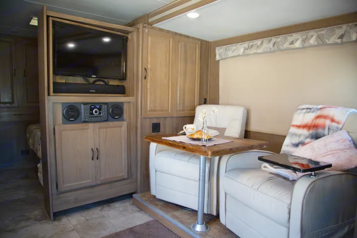 RV rental interior features a relaxing lounge with TV, sound system, and dining area for luxurious travel.. Forest River Coachmen Prism 2018