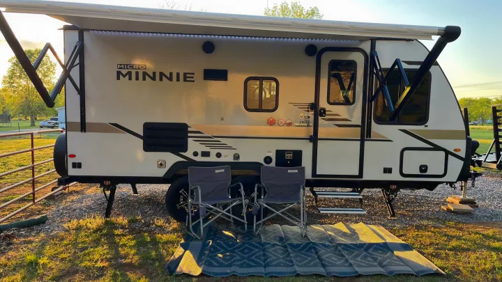 Winnebago Micro Minnie RV rental set up for camping, with awning extended & outdoor seating. Winnebago Micro Minnie 2021