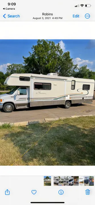 This image displays a Santara Class C RV for rental, parked outdoors under a clear blue sky. Ideal for road trips.. Coachmen Catalina Santara 2001
