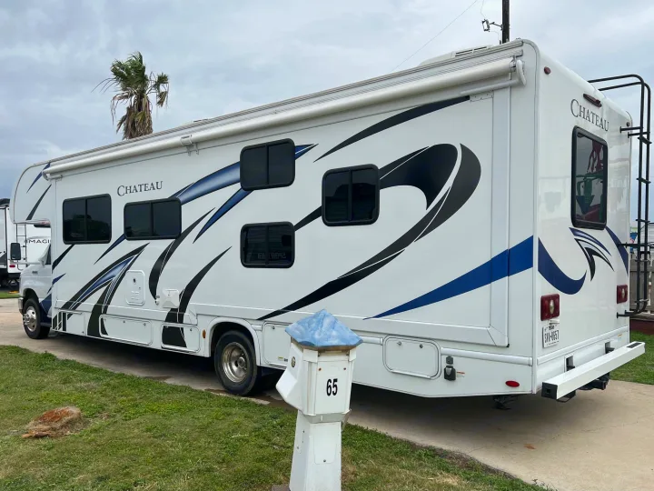 This spacious white Chateau RV rental, with blue/black graphics, is parked on pavement, ready for adventure.. Thor Chateau 2020