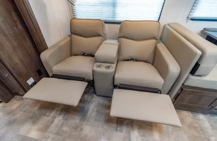 Relax in this RV rental's theatre seating: two recliners with extended footrests, cup holders, and a center console.. Coachmen Pursuit 2022