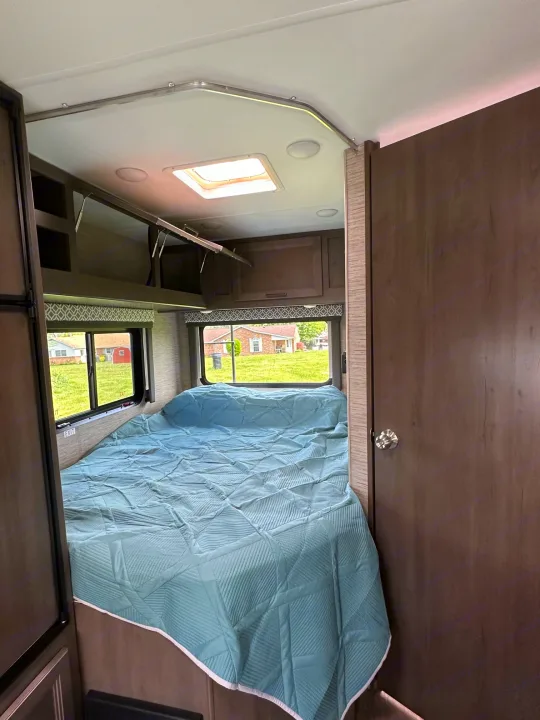 RV rental: Bright bedroom with light blue bed, windows, and bunk area. Modern interior for comfortable travel.. Thor Coleman 2023