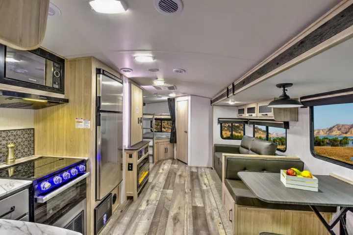Explore this RV rental's modern interior featuring a full kitchen, dining nook, lounge, and bunk beds.. Heartland RVs Sundance Ultra Lite 2022