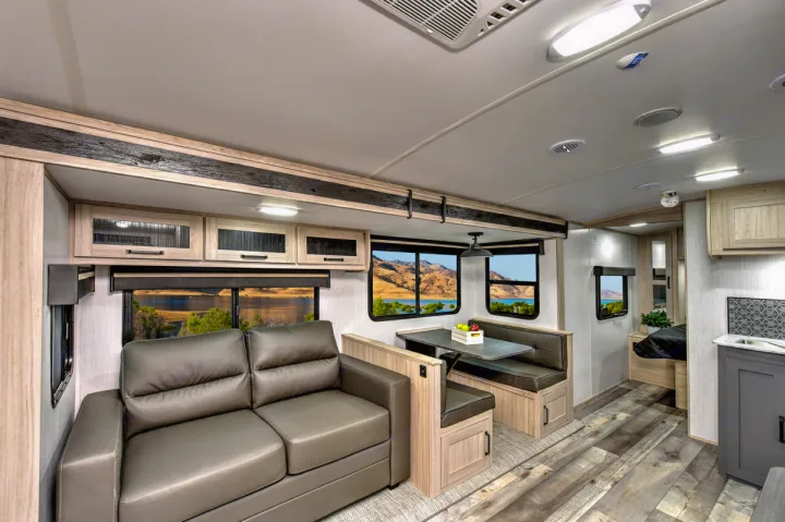 Explore this modern RV rental interior, offering a comfortable living space, dinette, kitchen, and private bedroom.. Heartland RVs Sundance Ultra Lite 2022