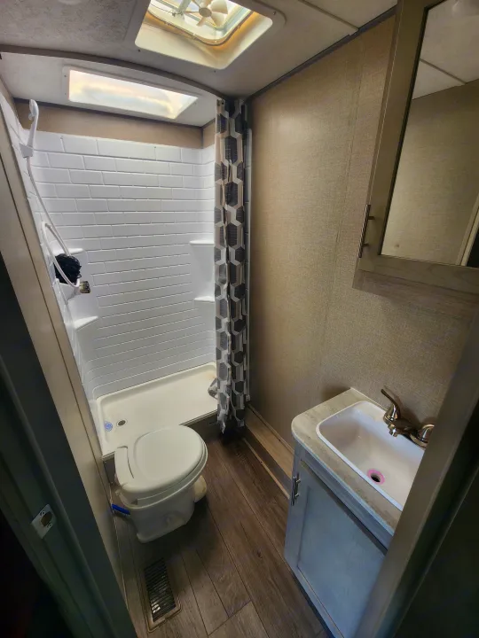This RV rental features a full bathroom: compact shower, toilet, sink, and mirrored cabinet. Clean and functional.. Coachmen Catalina 263 bunk 2022