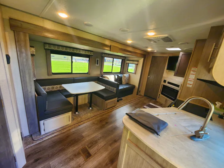 Step inside this modern RV rental: a spacious living area with a dinette, sofa, kitchen, and large windows.. Coachmen Catalina 263 bunk 2022