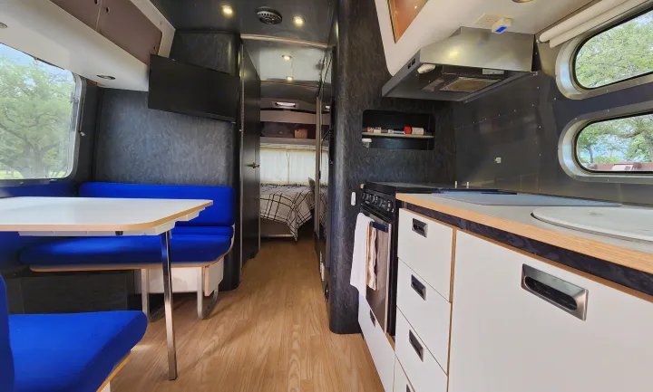 This rv rental features a well-equipped kitchen, a comfortable dining booth, and a private bedroom at the rear.. Airstream International 2004