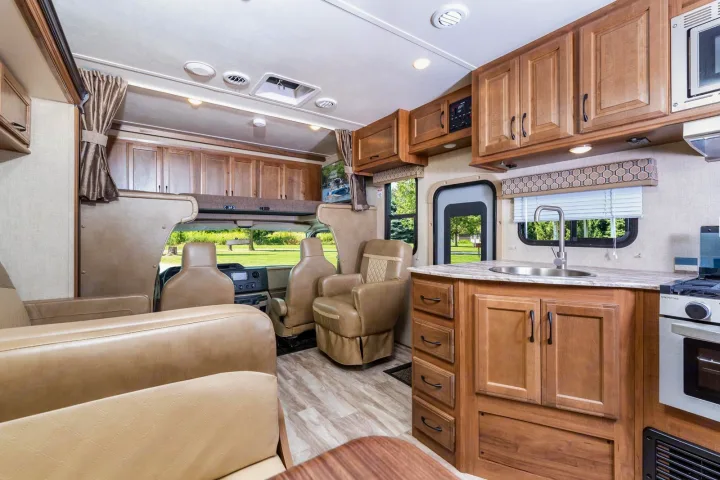 Inside an RV rental: a well-equipped kitchen, comfy living area, and sleeping bunk. Perfect for road trips.. Gulf Stream Conquest 2017