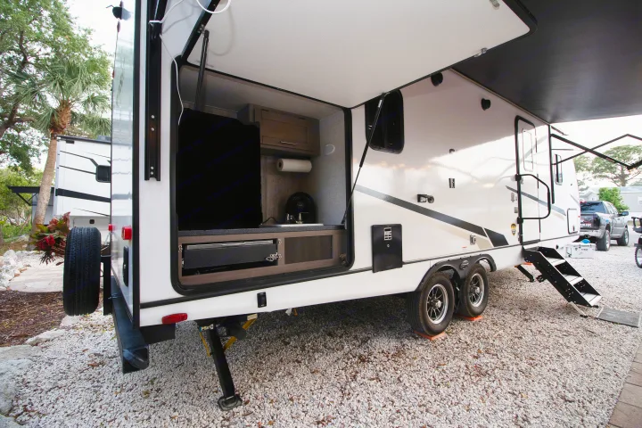RV rental with impressive outdoor kitchen, including TV and grill, plus extended awning and steps for comfortable outdoor living.. Crossroads RV Sunset Trail Super Lite 2022
