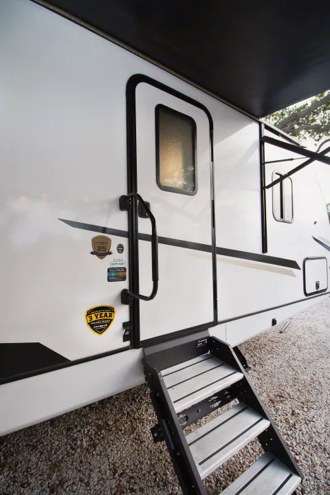 White RV rental entry with black steps, door, grab handle, and awning. Features CrossRoads RV & 3-year warranty decals.. Crossroads RV Sunset Trail Super Lite 2022