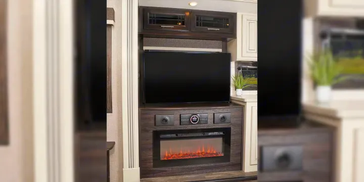 Modern RV rental interior featuring a cozy entertainment center with TV, electric fireplace, and stylish dark wood cabinetry.. Jayco Pinnacle 2022